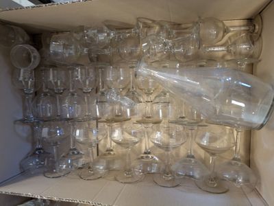 many empty wine glasses in a box on the shelf