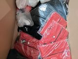 a cardboard box filled with clothes and bags of clothing