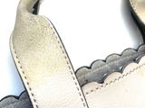 a white purse with a handle on a white surface