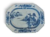 une assiette bleue et blanche sur laquelle est représenté un homme dans un bateau