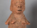 a close up of a clay statue of a person on a table