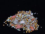 a pile of gold and silver crystals on a black surface