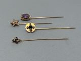 trois paires de boucles d'oreilles en or et en améthore sur un fond gris
