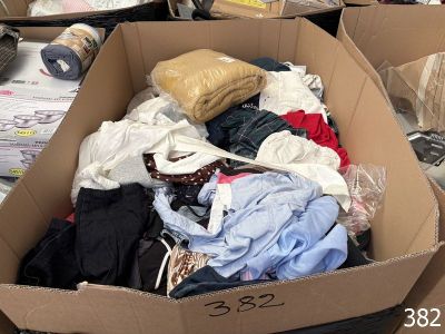 a cardboard box full of clothes on the floor