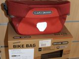 a red bag sitting on top of a cardboard box