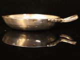 a silver spoon sitting on top of a black table