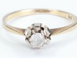 a close up of a diamond ring on a white surface