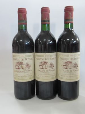 three bottles of red wine sitting on top of a white table