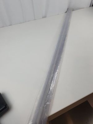une table blanche sur laquelle se trouvent un ordinateur portable et un rouleau de film plastique