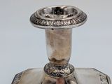 an antique silver plated candle holder on a white background