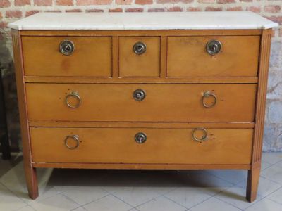 une commode en bois avec un plateau en marbre, posée sur un sol carrelé
