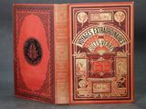 un vieux livre à la couverture rouge posé sur une table