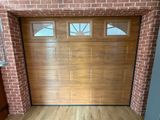 une photo d'une porte de garage en bois dans un bâtiment en briques