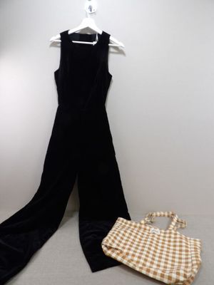 a black jumpsuit and a handbag on a hanger