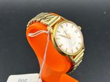 an orange bracelet watch with a white dial on a black surface