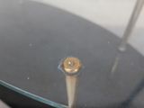 a metal object with a gold button on top of it