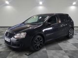 la photo d'une voiture noire garée sur un sol en damier