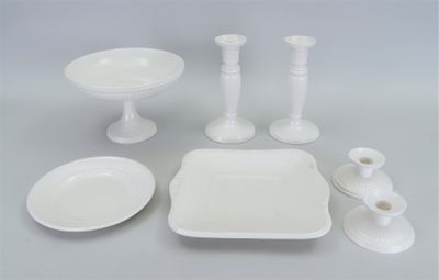 beaucoup de vaisselle blanche et de bougies sur la table