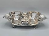 an antique silver plate with two cups and saucers on it