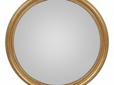 un miroir rond avec un cadre doré sur fond blanc