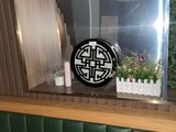un miroir accroché au mur au-dessus d'une table sur laquelle se trouve un vase de fleurs