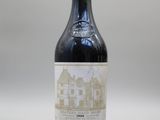 une vieille bouteille de vin posée sur une table blanche
