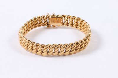 gros plan d'un bracelet en or sur fond blanc