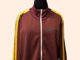 Le mannequin porte une veste de sport bordeaux et jaune.