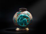 un vase orné d'un motif vert et doré