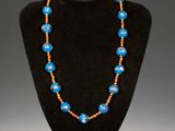a blue and orange beaded necklace on a black mannequin