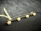 a close up of a hair pin with pearls on it