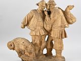 carved wooden sculpture of two men with a dog and a sheep
