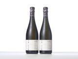 two bottles of wine sitting next to each other on a table