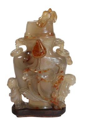une photo d'un vase sculpté sur lequel figure un oiseau