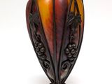 a vase that is sitting on a stand on a white surface