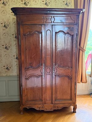 une grande armoire en bois dans le coin d'une pièce