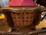 a wicker chair with a pink cushion on it