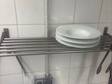 a metal shelf with plates on it in a kitchen