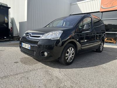 La petite camionnette noire est garée devant un immeuble.