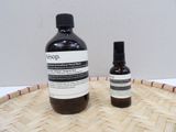a bottle of liquid sitting next to a bottle of liquid on a basket