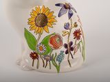 a white vase with a colorful flower design on it
