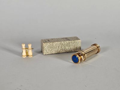 une paire de vis en laiton et un coffret en laiton posés sur une surface blanche