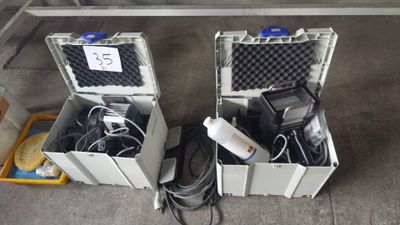 deux valises contenant du matériel électronique, posées par terre