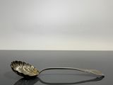 cuillère en argent avec un manche en forme de feuille sur un fond noir