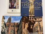trois livres posés sur une table, avec des photos de bâtiments et d'une statue