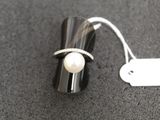 a ring that has a pearl on it and a tag on it