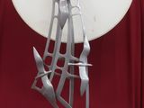 une sculpture métallique représentant un voilier, posée sur une assiette blanche