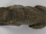an old bronze figurine of a cat on a white surface