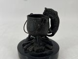 une petite statue représentant un oiseau posée sur une tasse