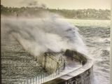 une photo montrant une grande vague déferlant sur un mur